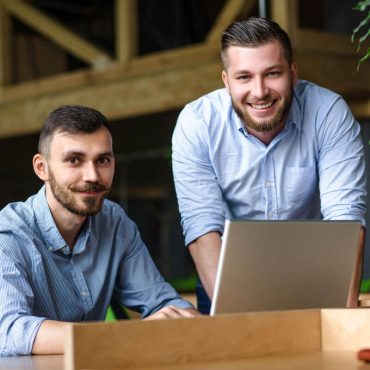 picture-handsome-businessman-listening-his-colleague-partner-concerning-ner-business-system-while-working-laptop-computer-office-interior